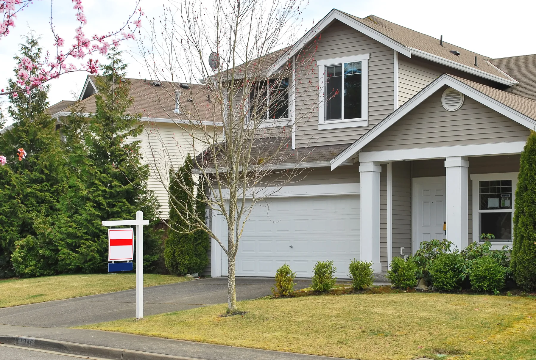 Two-story detached home with a for-sale sign